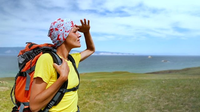 Hiking woman trekking along blue lake Baikal. Caucasian girl living active lifestyle