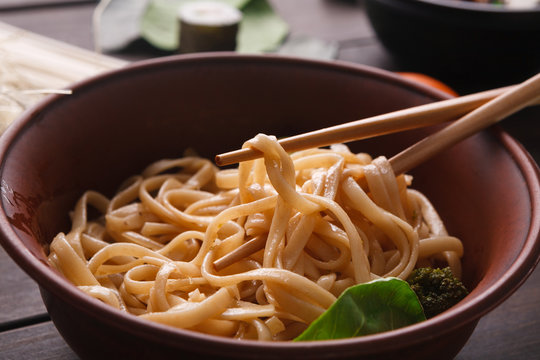 Bowl of rice noodles with soy souce on wood