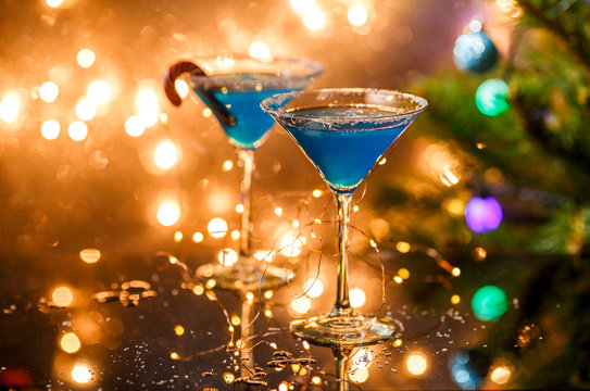 Christmas photo of two wine glasses with blue cocktail and garland