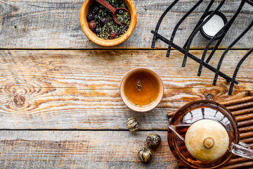 Accessories for tea ceremony. Tea pot, cups, dry tea leaves on rustic wooden background top view copyspace