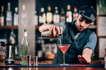Barman pouring fresh cosmopolitan drink