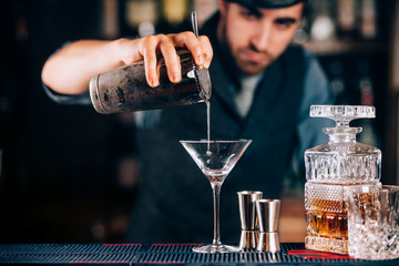Dry martini close up. Preparation of martini at bar. Portrait of barman