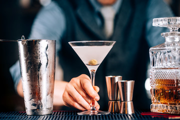 Close up of dry martini with green olive served cold at restaurant