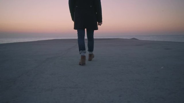 Camera follows heavy duty brown leather boots with handmade wool socks walk in slow motion towards sunset or sunrise. concept forever young, adventure, explore more, travel inspiration