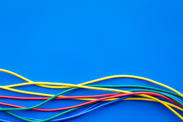 Network colored cables for computer on blue background top view copyspace