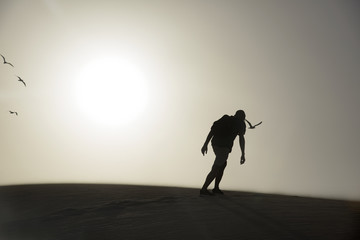 young man with a backpack in the desert