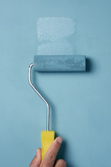 Obraz premium young man painting with a paint roller