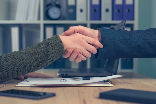Man and woman shaking hands over business agreement