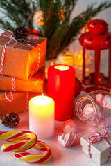 Christmas decor of a candle, gifts, marshmallow in a festive atmosphere background with copy space