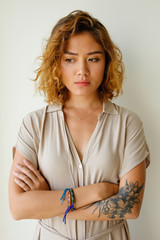 Displeased young Asian woman standing in studio