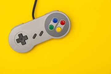 Retro computer gaming controller on a bright yellow background