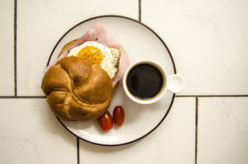 Small fast breakfast from egg, ham, bun and coffee