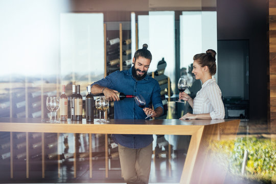 Man and woman tasting wine at winery.