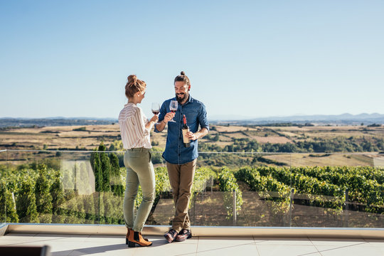 Couple enjoying drinking wine at vineyard - Powered by Adobe