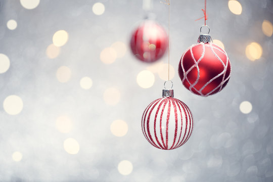 Image of three Christmas red balls on gray background with spots.