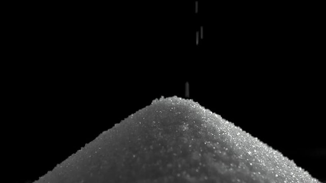 Pile of sugar on black background shooting with high speed camera