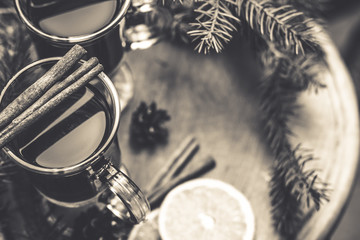 Mulled wine hot drink with citrus and spices in a glass cup and Spruce branch on a concrete background