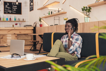 african american man talking on smartphone in coffee shop