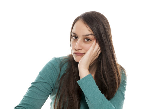 Borred young woman on a white background