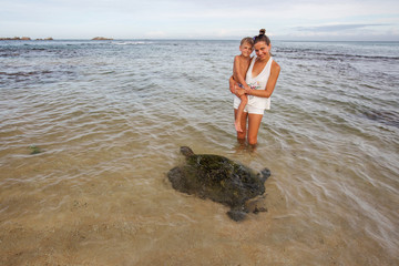 Family snorkeling with turtle  at the tropical coast of Sri Lanka