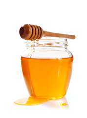 glass jar full of honey and dipper