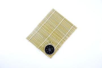 isolated compass and bamboo mat in white background