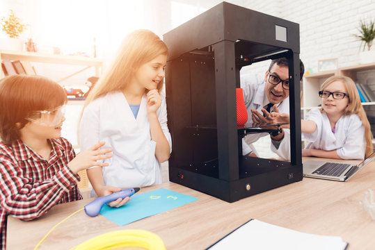 Children print different items on a 3d printer with a teacher.