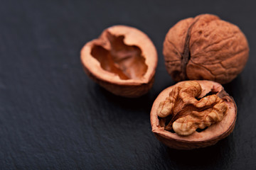 Healthy food concept Spot focus natural walnuts kernel on black slate stone background with copy space