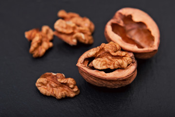 Healthy food concept Spot focus natural walnuts kernel on black slate stone background with copy space