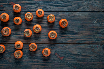 Delicious ripe appetizing persimmon fruit on a dark wooden table
