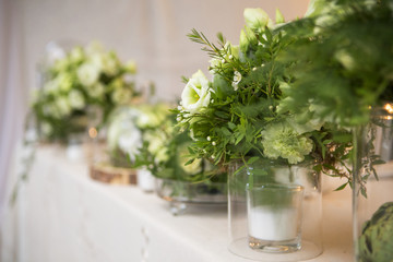 Fresh eustoma roses bouquet composition on a table in a glass vase. Wedding bridal decor. Dim dark sunset light. Romantic mood