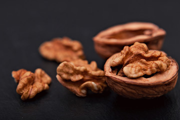 Healthy food concept Spot focus natural walnuts kernel on black slate stone background with copy space