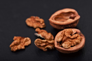 Healthy food concept Spot focus natural walnuts kernel on black slate stone background with copy space
