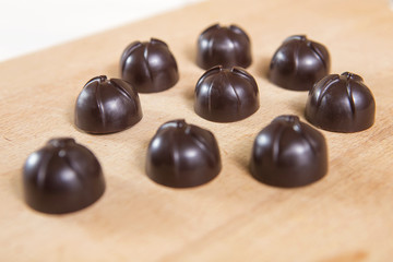 Homemade no sugar proper nutrition chocolate candies on a wooden background. Healthy food