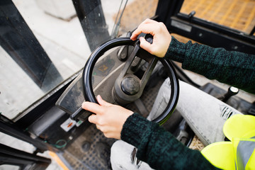 Woman forklift truck driver in an industrial area.