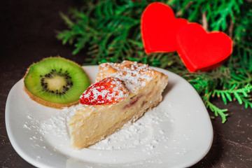 Cheesecake on Valentine's Day with strawberry and hearts on fir and concrete background for you card