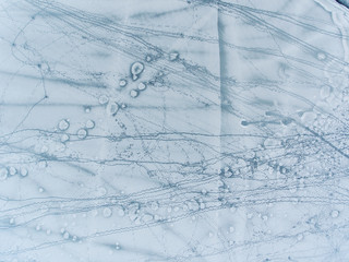 Aerial top down view over icy lake surface pattern, near Grutas park, Lithuania.