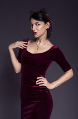 Fototapeta premium Portrait of a beautiful brunette caucasian woman with short straight hair and red lips on a neutral grey background. Romantical sexy mood