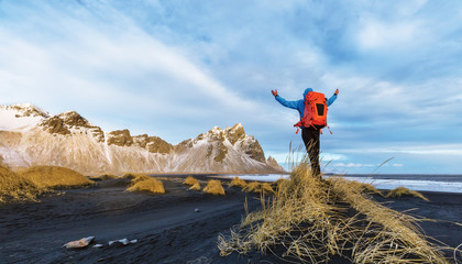 Young man traveler with backpack, celebrating with gesture, Iceland.