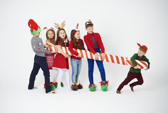 Playful children with big candy cane  .