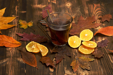 Cup of green tea with spoon put on beautiful leaves.