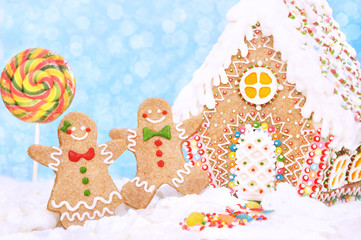 Homemade gingerbread house and gingerbread man cookies, festive bright Christmas and New Year sweeties card