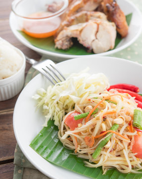 Green papaya salad,Som tum Thai and grilled chicken on wood table