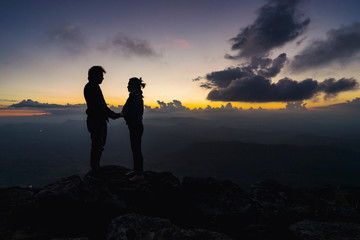 Silhouette of loving couple embracing on the mountain