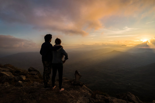 Silhouette of loving couple embracing on the mountain