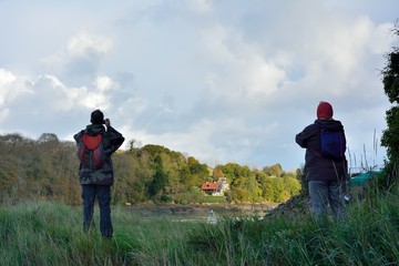 Fototapeta na wymiar Randonneurs qui observent le paysage des rives du Guindy près de Tréguier en Bretagne