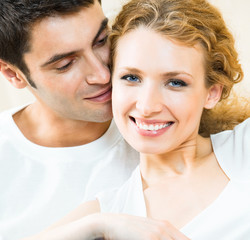 Cheerful smiling young couple, indoors