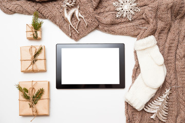 Top view tablet with blank screen on wooden table with fir tree and Christmas decoration. Christmas background.