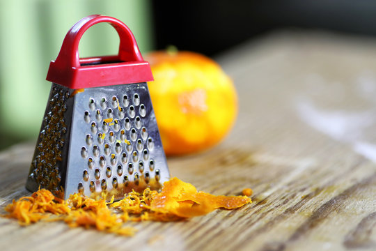 grater zest of citrus fruit and on wooden table