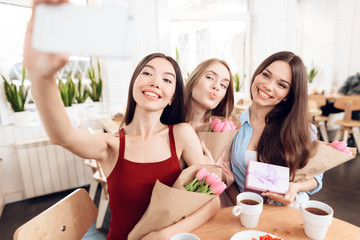 Three girls do selfie, celebrating the holiday on March 8.